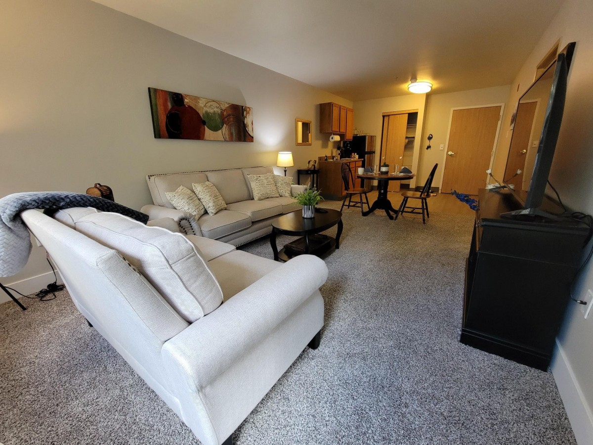 A modern living room with comfortable sofas and a cozy dining area.