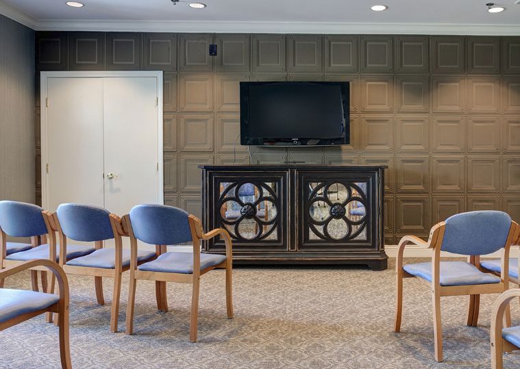 A conference or waiting room with chairs and a television on the wall.