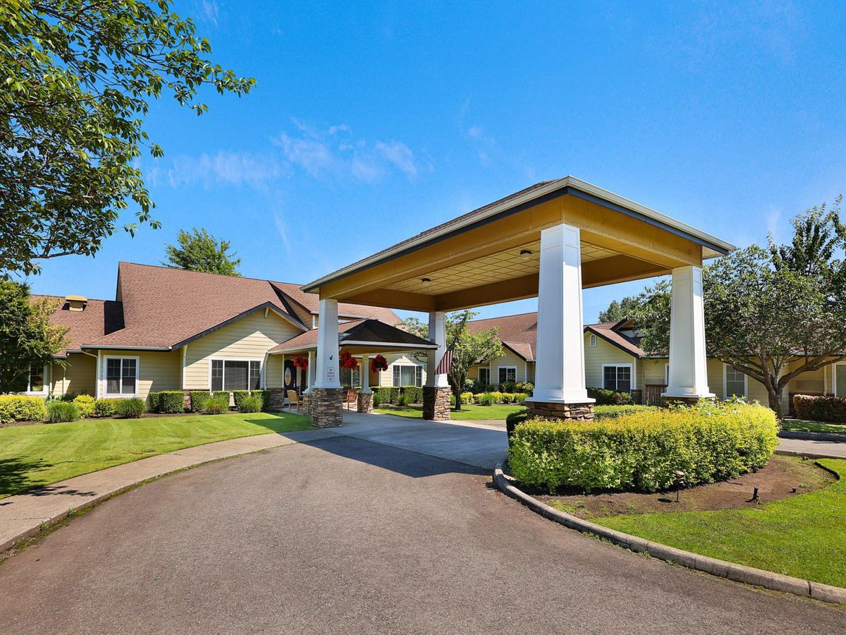 A building with a covered entrance and well-maintained landscaping.
