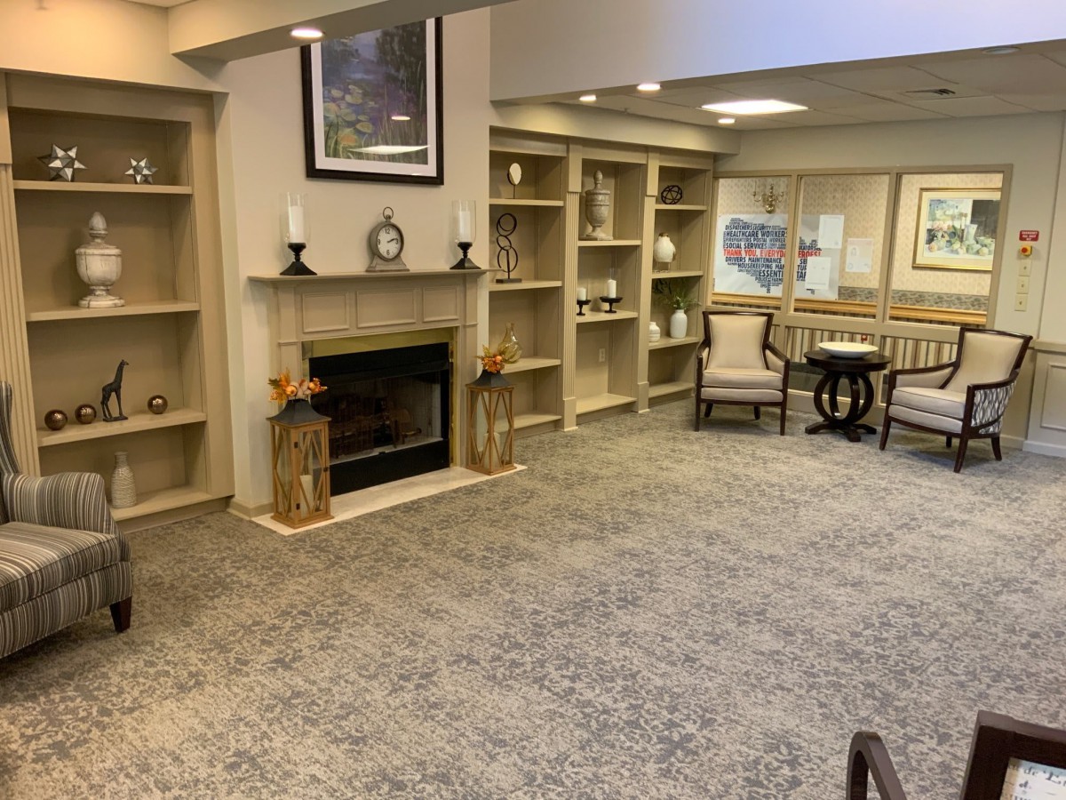 A cozy living room featuring a fireplace, bookshelves, and comfortable seating.