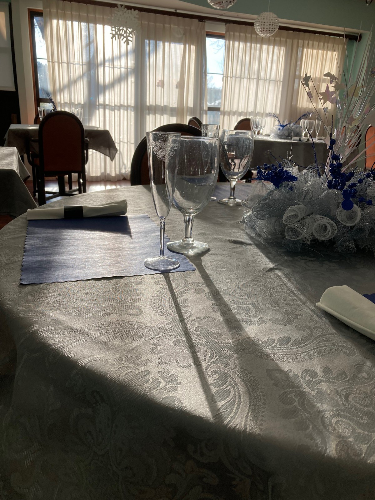 An elegantly set restaurant table bathed in sunlight.