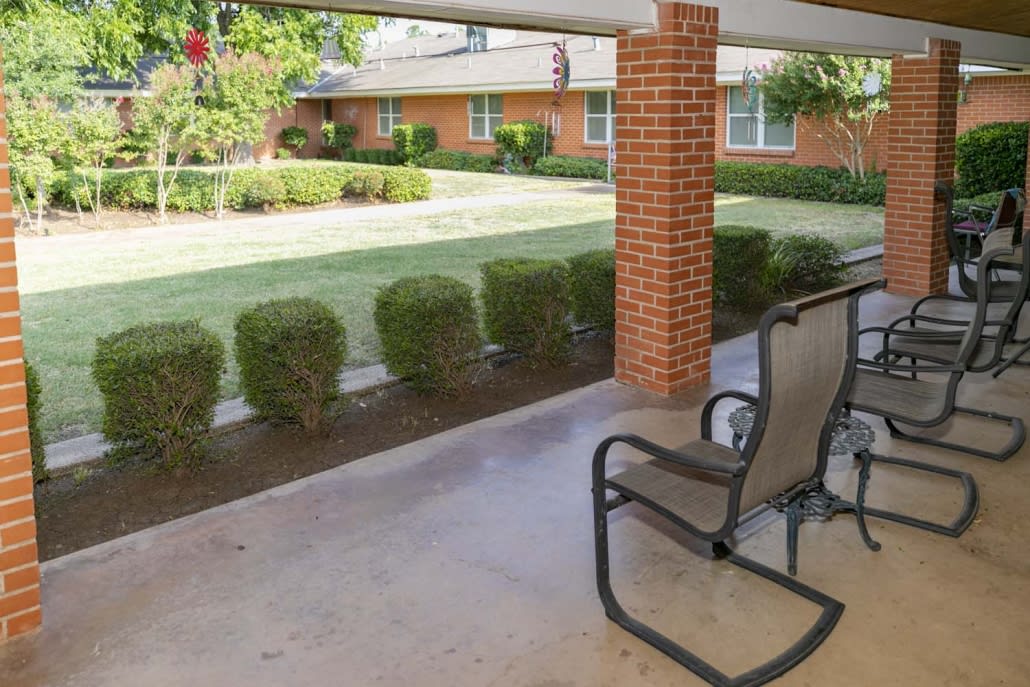 A cozy patio area with chairs overlooking a well-maintained garden.