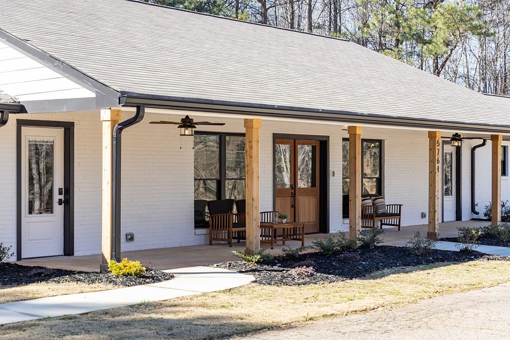 A cozy bungalow with a welcoming porch and outdoor seating area.