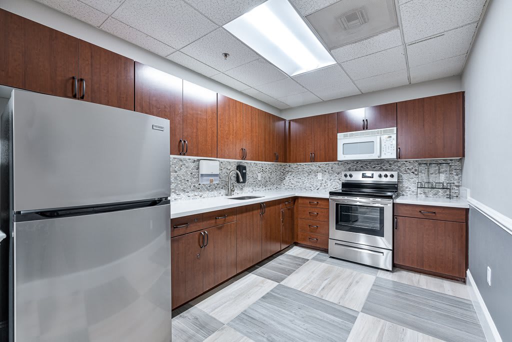 A modern kitchen with stainless steel appliances and wooden cabinetry.