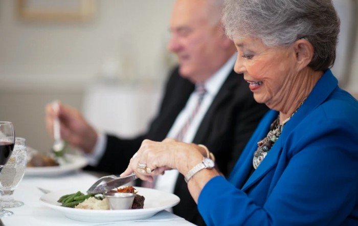 Two senior adults enjoying a formal meal together.
