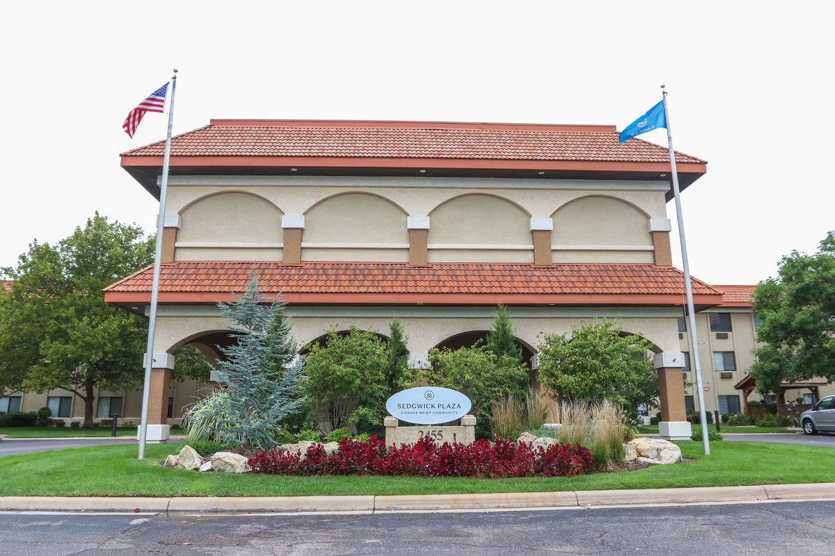A two-story building with flags and well-maintained landscaping in front.