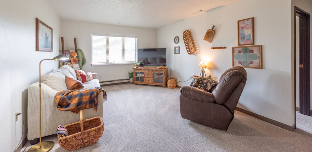 A cozy living room with comfortable seating, a television, and decorative elements.