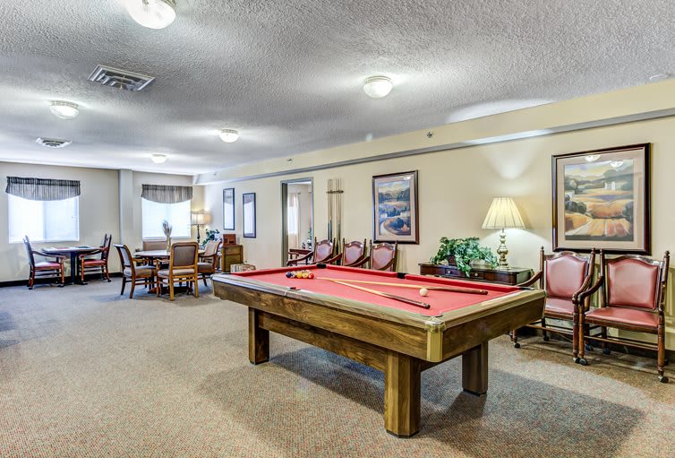 A cozy game room featuring a billiard table and dining area.