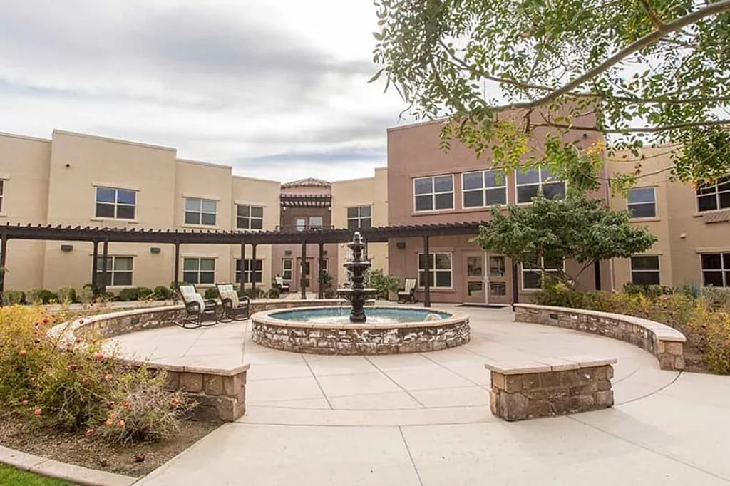 A courtyard featuring a central fountain surrounded by a building.