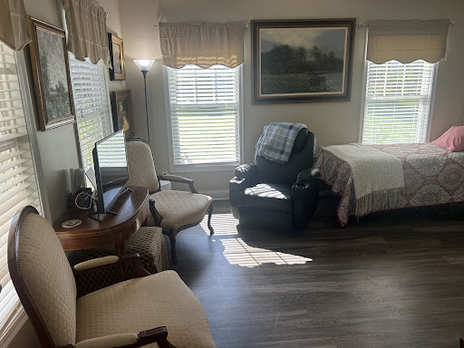 A cozy room featuring a bed, recliner, and comfortable seating area with natural light.