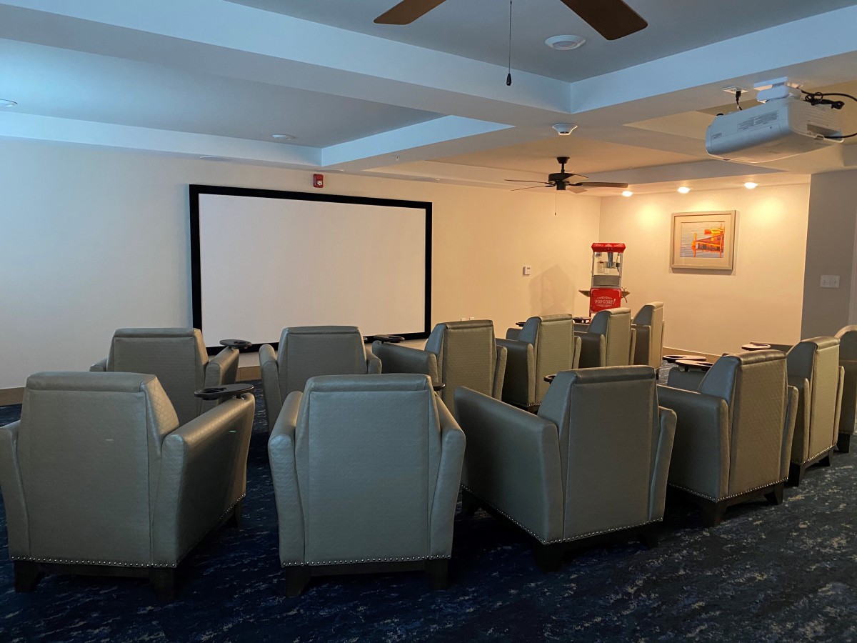 Cozy home theater room with comfortable seating and a large screen.