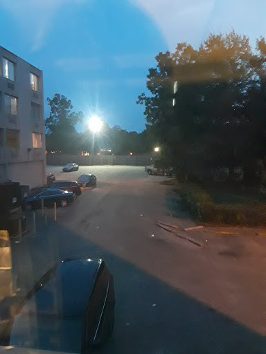 A quiet evening scene in a parking lot illuminated by street lights.