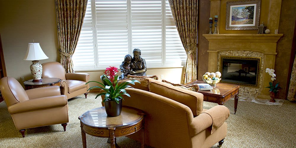 A cozy living room with comfortable sofas, decorative tables, and a large window with curtains.