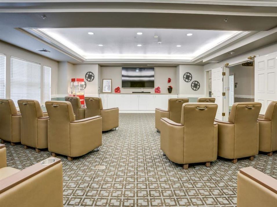 A cozy movie room with recliner seating and a popcorn machine, perfect for an immersive viewing experience.