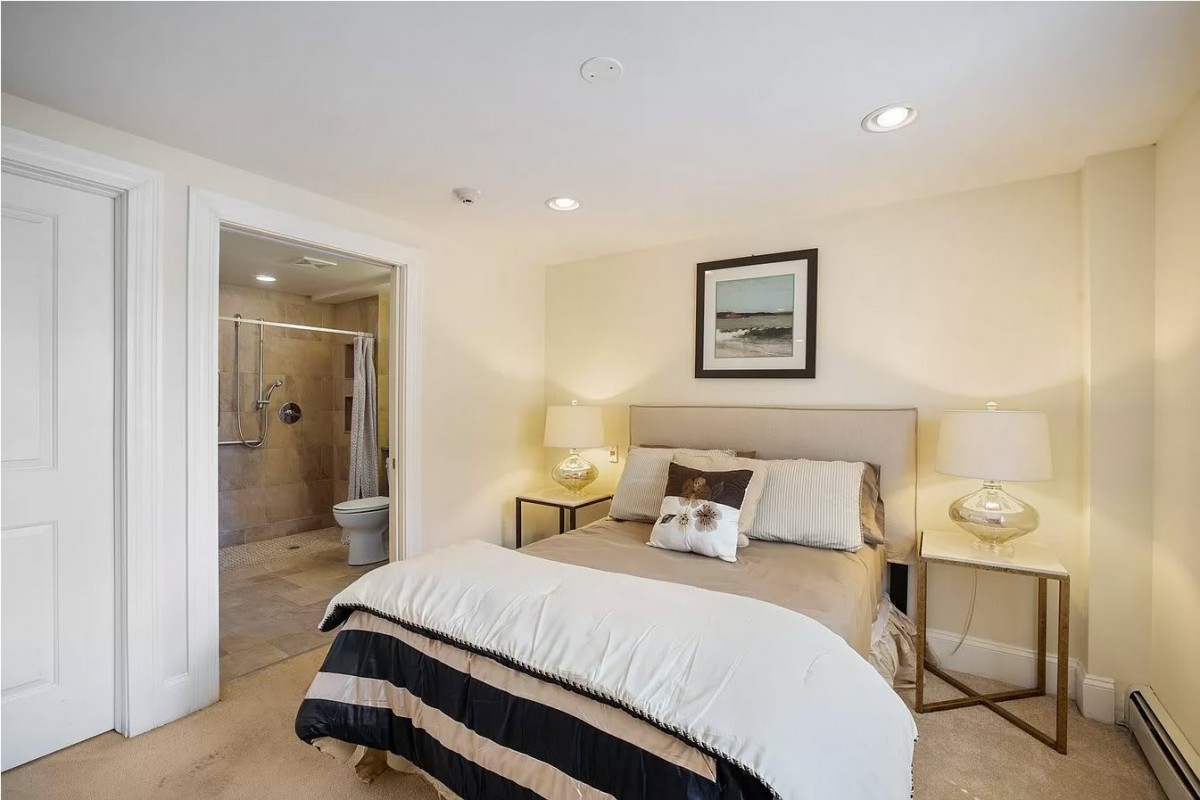 A cozy, well-lit bedroom with a comfortable bed, decorated with neutral tones and featuring modern furniture.