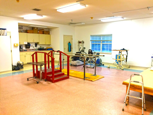 A spacious gym equipped for various fitness and rehabilitation activities.
