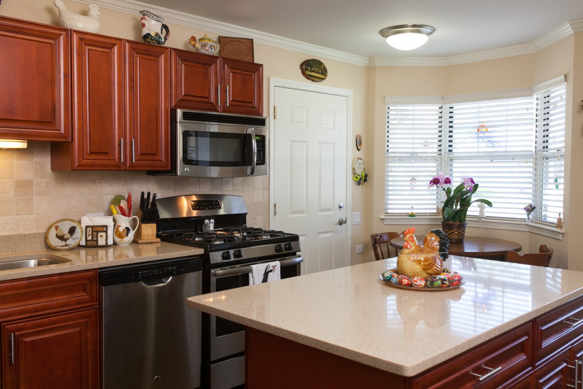 A modern kitchen featuring stainless steel appliances, wooden cabinets, and a spacious countertop.