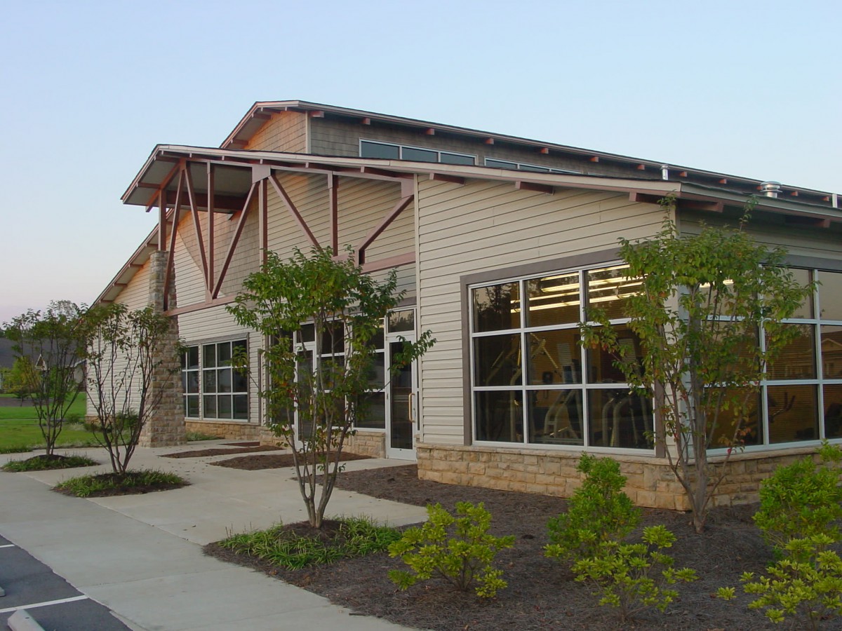 A modern building exterior with large windows and landscaped surroundings.