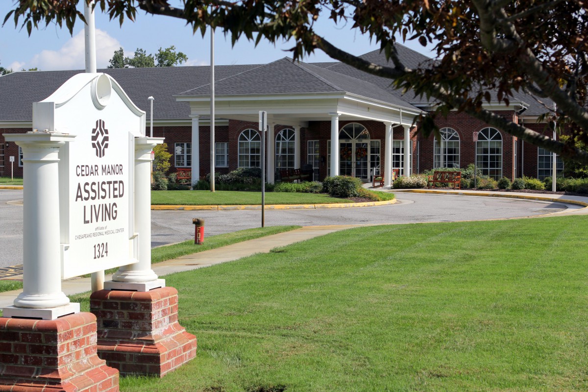 The exterior view of a library with a welcoming entrance and a well-maintained lawn.