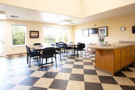 A spacious dining area with checkered flooring and natural light.