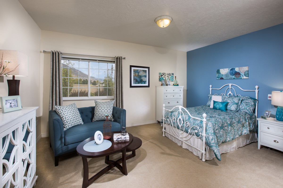 A cozy bedroom with a blue and white theme featuring a comfortable sofa and a decorative bed.