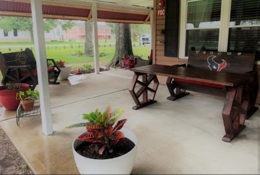 A cozy outdoor patio area featuring a wooden table and decorative plants, perfect for relaxation.