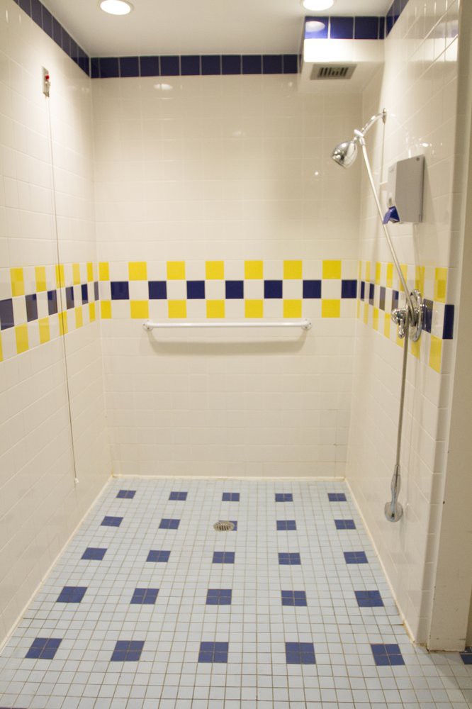 A modern shower space with yellow and blue tiled patterns.