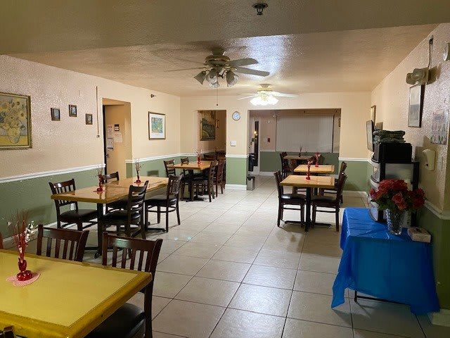 An empty restaurant dining area with neatly arranged tables and chairs.