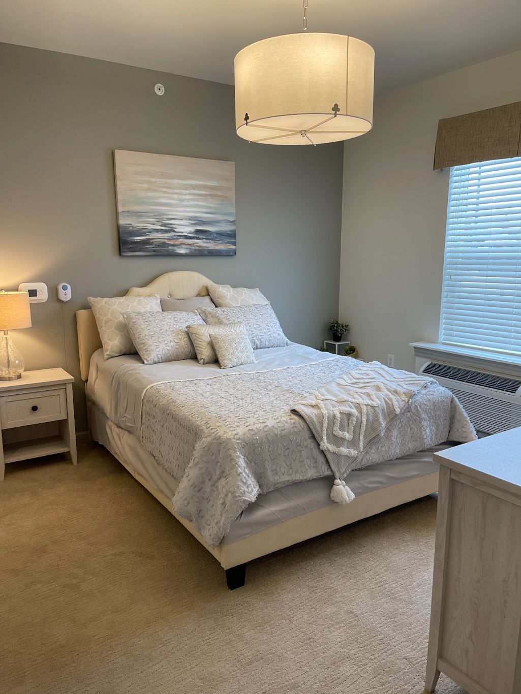 A cozy, well-decorated bedroom with a neatly made bed and soft lighting.