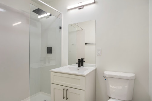 A modern bathroom featuring a sleek design with a shower, sink, and toilet.