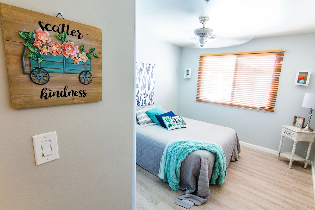 A cozy bedroom with a neatly made bed and decorative wall art.