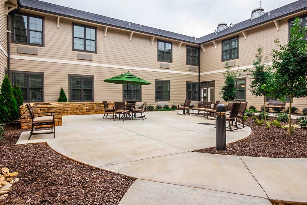 A well-maintained courtyard with seating arrangements and landscaping, surrounded by a building exterior.