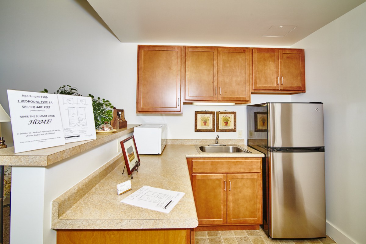 A modern kitchen with wooden cabinets and stainless steel appliances.