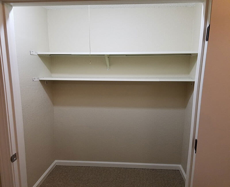 An empty closet with two shelves.