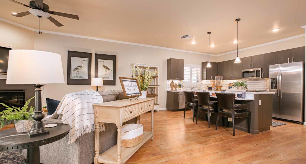 A modern open floor plan featuring a cozy living room with stylish furniture and a connected kitchen area.