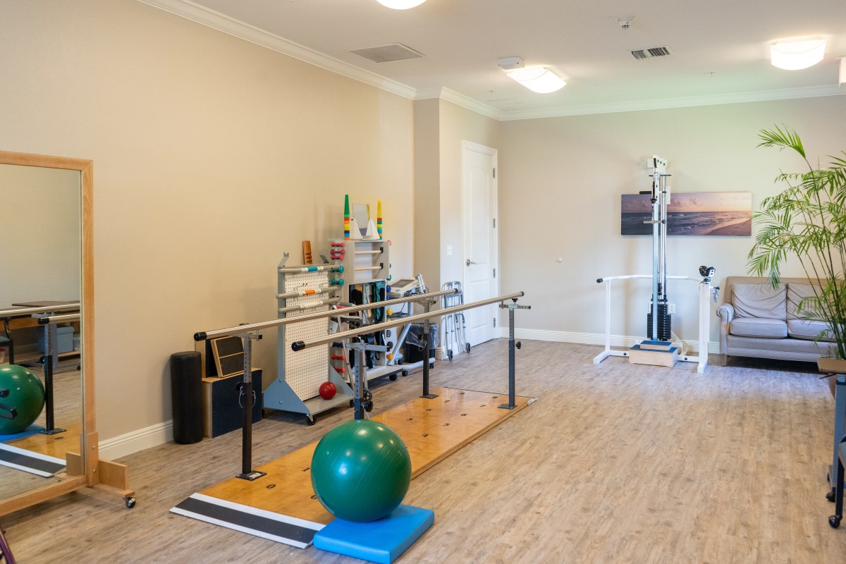 A rehabilitation room equipped with parallel bars and exercise tools.