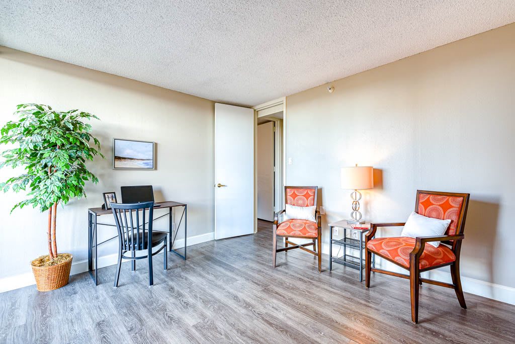 A cozy office space with a desk, chairs, and decorative elements.