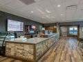 A modern cafe interior featuring a wooden counter and menu board.