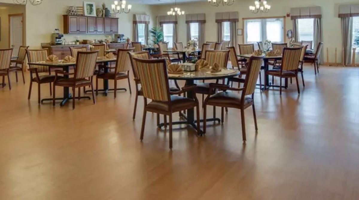 An empty dining room with neatly arranged tables and chairs.