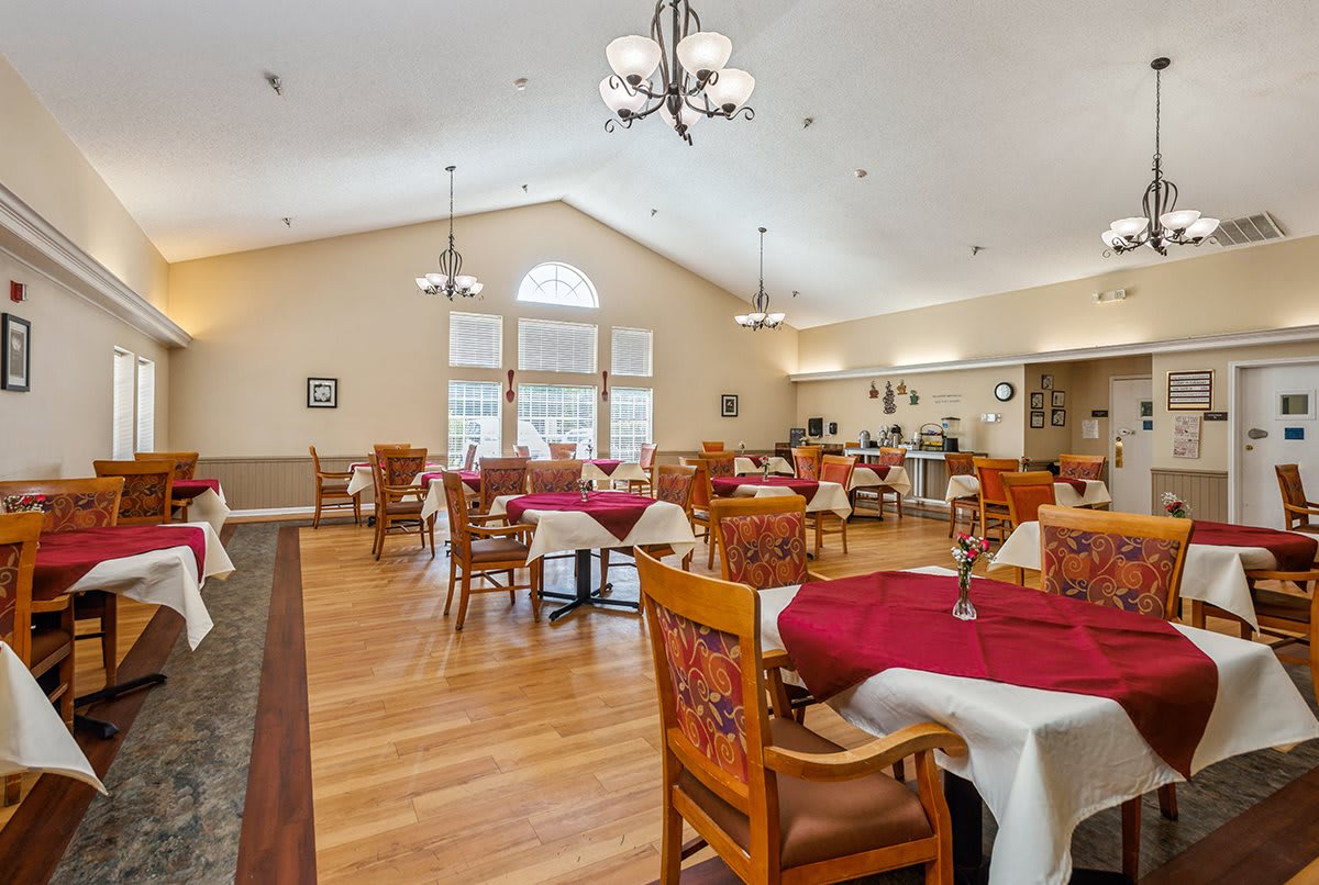 A spacious dining area with elegantly set tables and warm lighting.