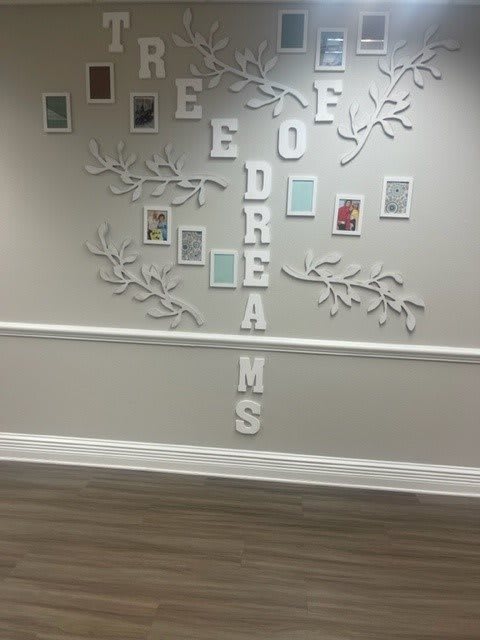 A wall with decorative tree branches and letters forming the phrase 'Tree of Dreams'.