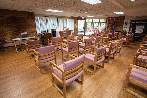 A serene worship space featuring wooden chairs arranged for a gathering.