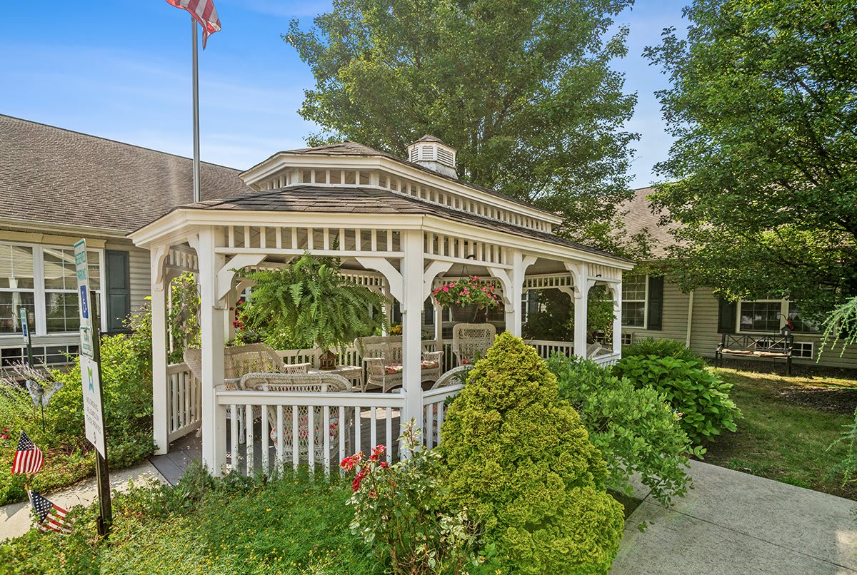 A charming gazebo surrounded by lush greenery and vibrant garden landscaping.