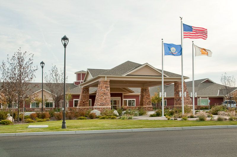 A building with multiple flags outside on a clear day.