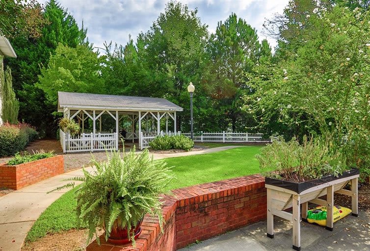 A peaceful garden with a gazebo surrounded by lush greenery.