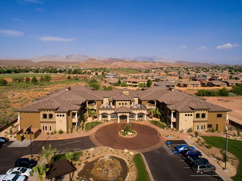 Aerial view of a suburban residential building surrounded by a desert landscape.