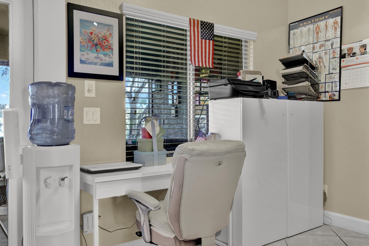 A neatly organized home office with a desk, chair, and American flag decor.