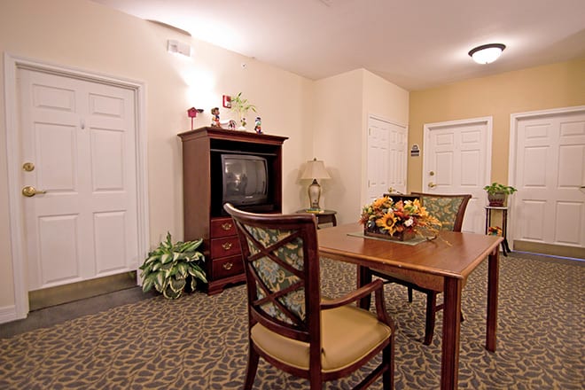 A cozy living room with a dining table, chairs, TV cabinet, and indoor decor.