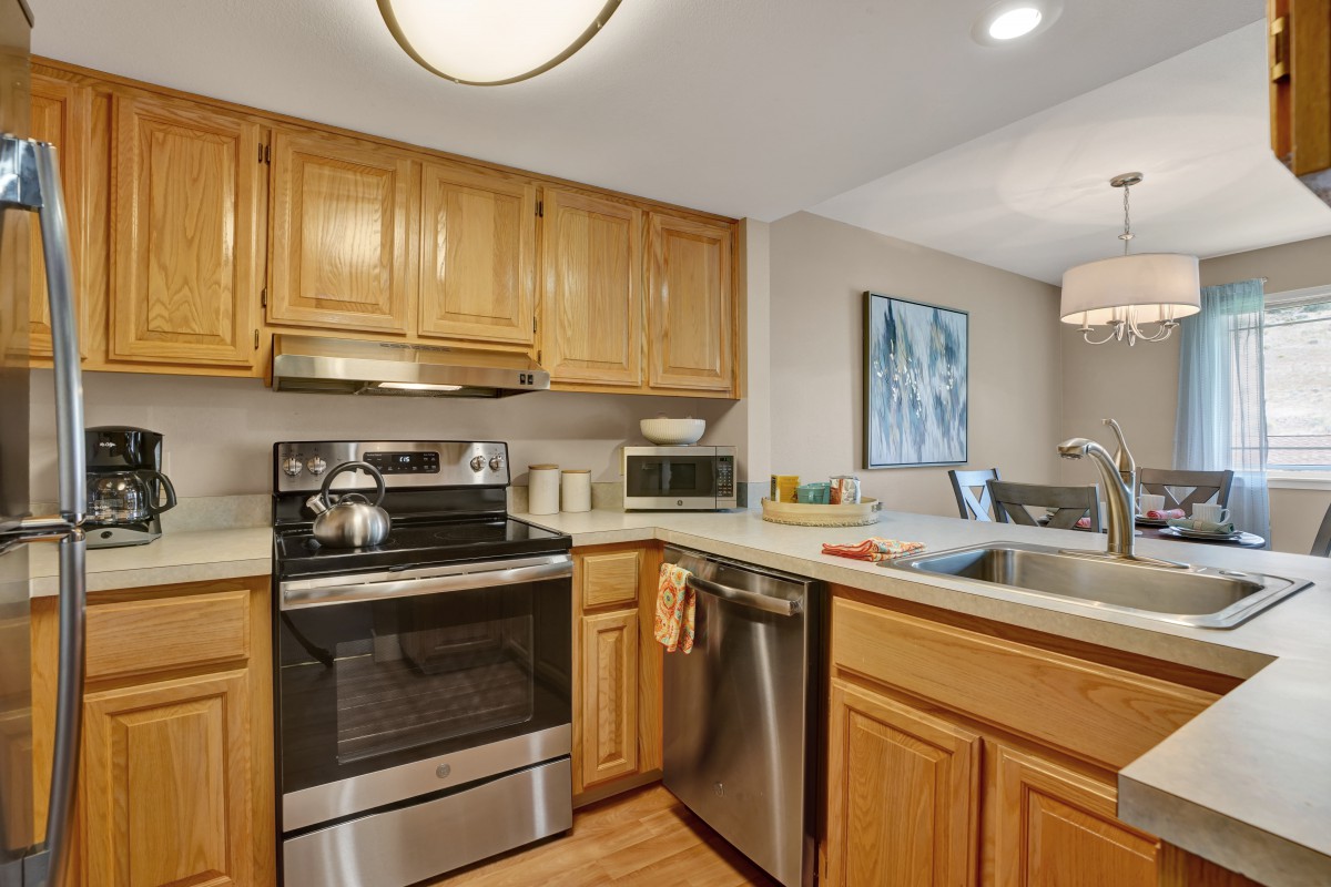 A modern kitchen with wooden cabinets, stainless steel appliances, and a welcoming layout.