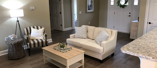 A cozy living room featuring a light-colored sofa and a wooden coffee table.